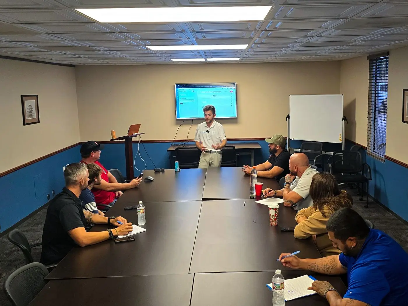 Noah teaching a roofing sales team around a conference table