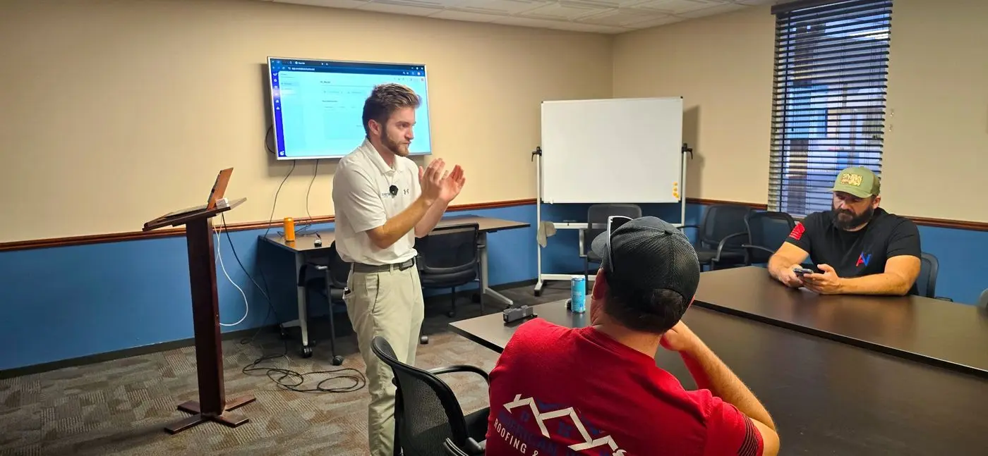 Noah explaining a sales step to roofing reps in a conference room