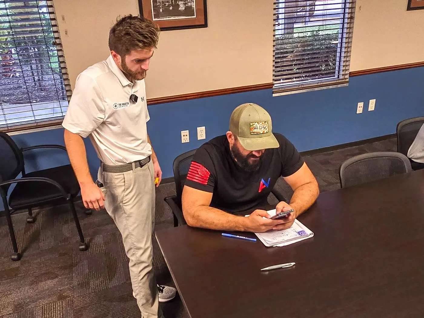 Noah standing beside a seated rep reviewing his worksheet