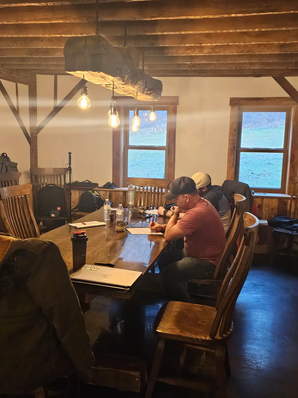 Sales reps at a long wooden table writing in their workbooks