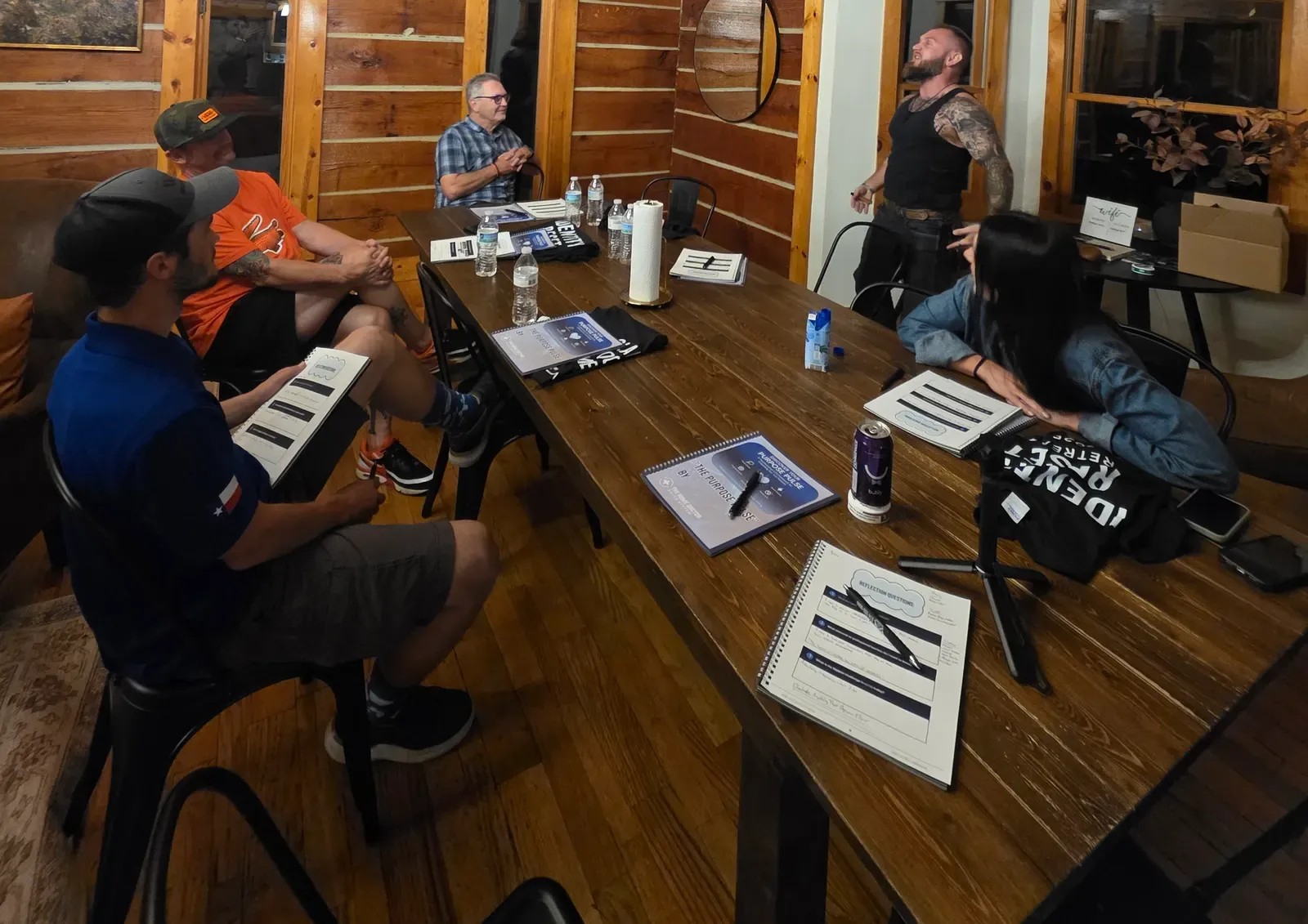 Leaders around a cabin table with Purpose Pulse workbooks
